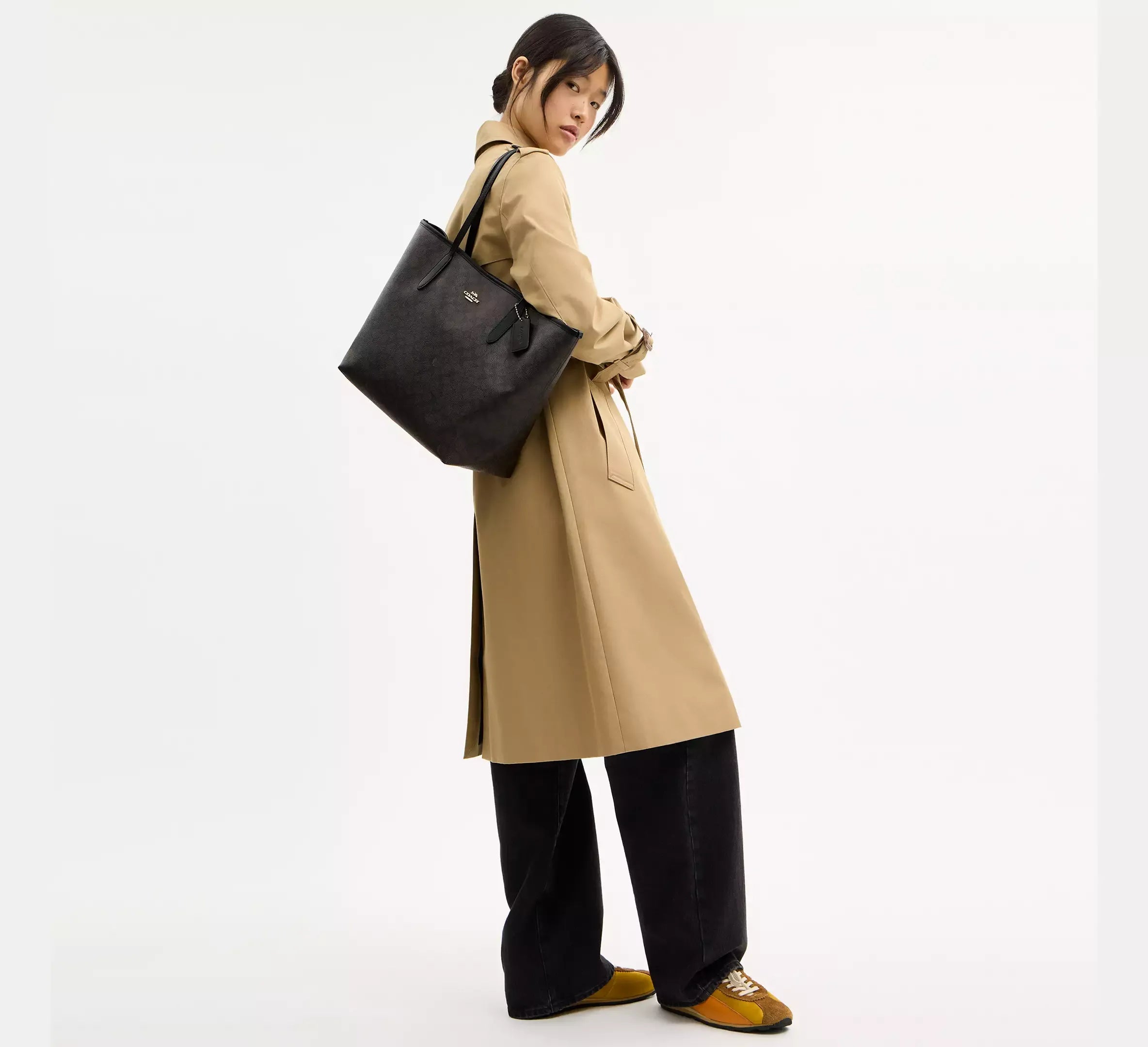 Black tote bag styled with a neutral trench coat